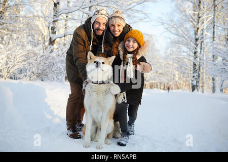 Family Posing with Dog Outdoors Stock Photo
