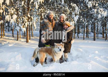 Happy Family Posing with Dog in Winter Stock Photo