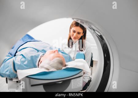 friendly doctor preparing elderly patient for CT Scan in hospital Stock Photo