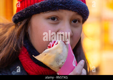 Asian American girl eating crepe Stock Photo