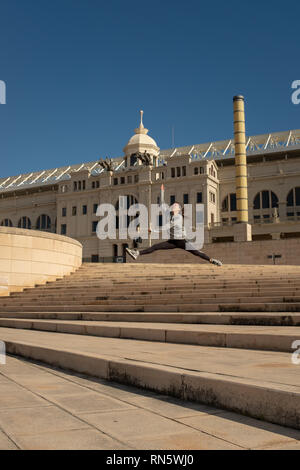 A young attractive girl makes a dance jumps leap along the staircase leading to the 'Estadi Olímpic Lluís Companys', Barcelona, Spain Stock Photo