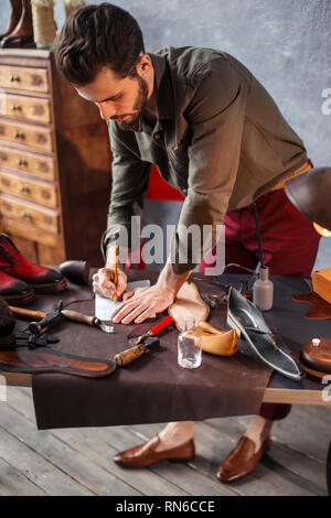 young man is interested in shoe design, student learning the basics of shoe design . side view close up photo Stock Photo