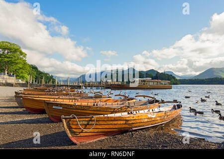 Row of wooden row boats lined up on the shore of Derwent water, Keswick, Cumbria. Stock Photo