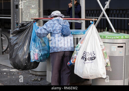 A middle aged Asian woman collecting deposit bottles in Greenwich Village, New York City. Stock Photo