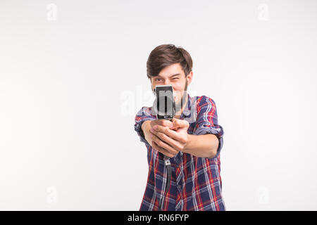 Funny people, photo and vintage concept - young man using vintage camera on white background Stock Photo