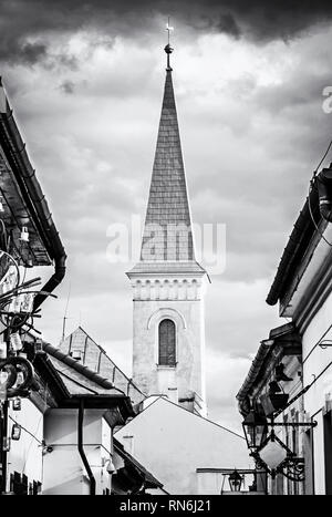 Hrnciarska street with Calvinist church in Kosice, Slovak republic. Folk art theme. Religious architecture. Black and white photo. Stock Photo