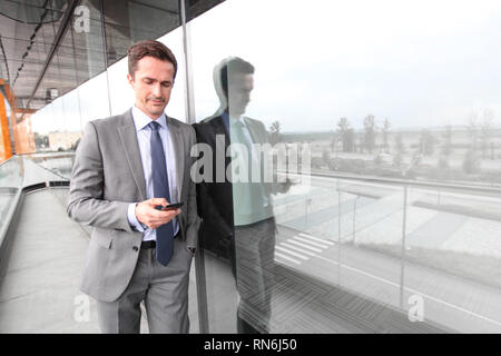 Businessman using smart phone at the balcony of office building Stock Photo