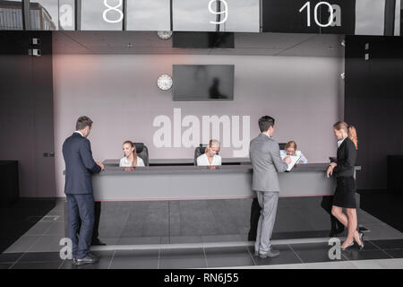 Business people at reception or front desk in office building, hotel or airport Stock Photo