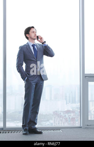 Portrait of a successful man, having a business conversation, at work station by the window Stock Photo