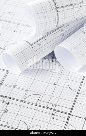 Rolls of architectural blueprint house building plans on blueprint background on table Stock Photo