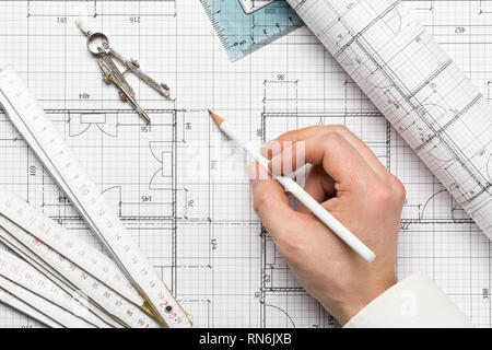 Architect pointing on architectural blueprint house building plan with pencil, ruler, compasses and square flatlay top view from above Stock Photo