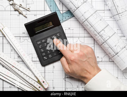 Architect using calculator on architectural blueprint house building ...
