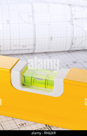 Orange construction level on architectural blueprint building plan close up - selective focus Stock Photo