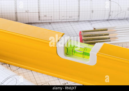Orange construction level on architectural blueprint building plan close up - selective focus Stock Photo