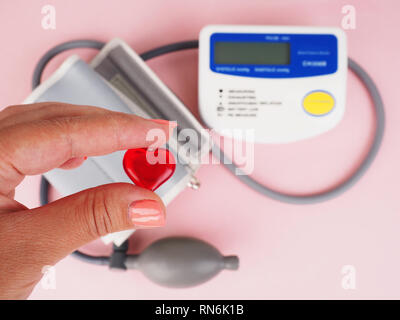 Blood Pressure Monitor on pink background. Medical equipment. Tonometer. Stock Photo