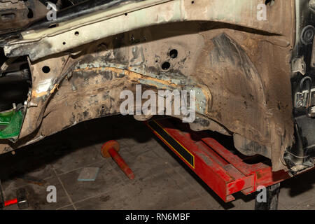 Close-up of two car body parts connected by spot welding after an accident in a vehicle repair shop Stock Photo