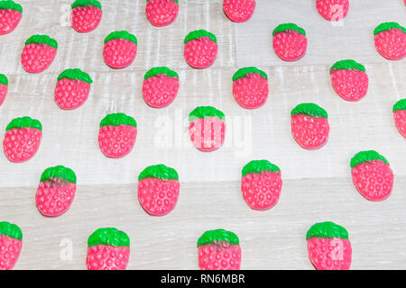 Strawberry candies diagonally on a light wooden background Stock Photo