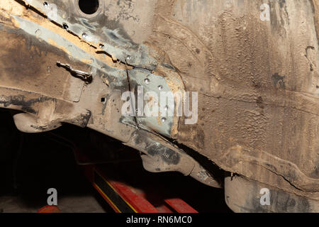 Close-up of two car body parts connected by spot welding after an accident in a vehicle repair shop Stock Photo