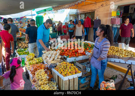 Mexican female seller at greengrocer stand at a market and local people, Tlacolula, Oaxaca, mexico Stock Photo