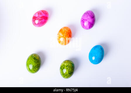 Flat lay of colorful painted easter eggs laying on white background Stock Photo