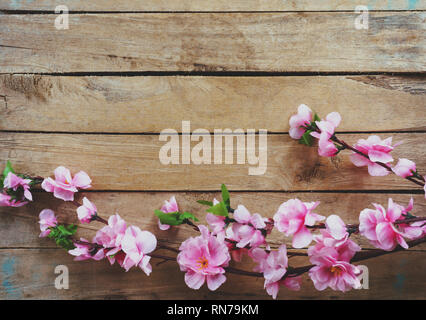 Cherry blossom and Artificial flowers on vintage wooden background with copy space. Stock Photo