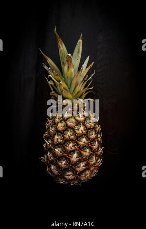 Pineapple isolated on black wood background, ananas tropical fruit Stock Photo