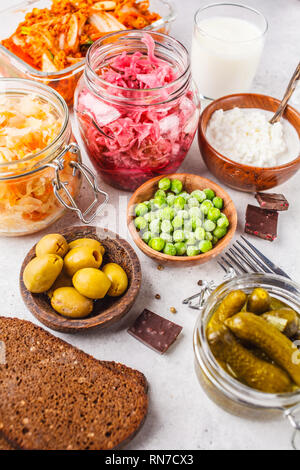 Probiotics food background. Kimchi, beet sauerkraut, sauerkraut, cottage cheese, olives, bread, chocolate, kefir and pickled cucumbers in glass jars,  Stock Photo