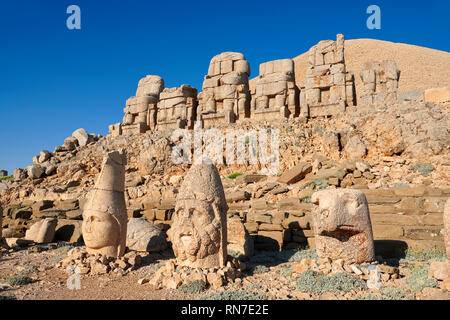 Statue heads, from right, Eagle, Herekles & Apollo with headless seated statues in front of the stone pyramid , east Terrace, Mount Nemrut or Nemrud Stock Photo