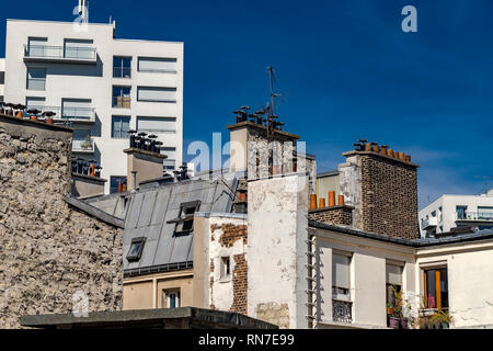 Paris building with attic rooms, tall chimney stacks and grey slate roof tiles  , Paris, France Stock Photo
