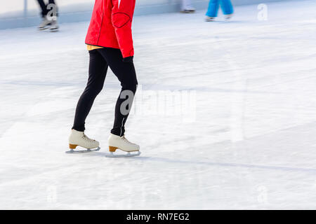 A young slender girl skates and helps beginners 2019 Stock Photo