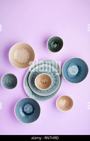 Beautiful blue, grey, beige dinnerware, plates bowls on lilac table, top view, selective focus Stock Photo