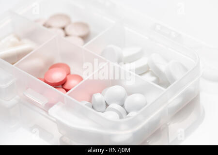 Close-up of pill case with various colorful pills, capsules on white background. Stock Photo