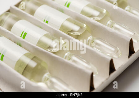 Close-up of four medical ampoules or vials or ampule with medicine in a box. Stock Photo