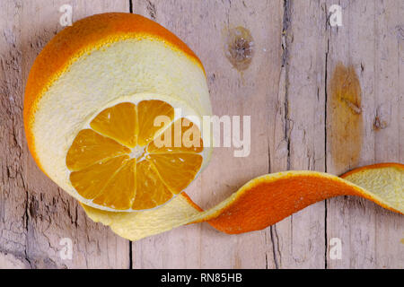 Ripe orange peeled on old wooden background
