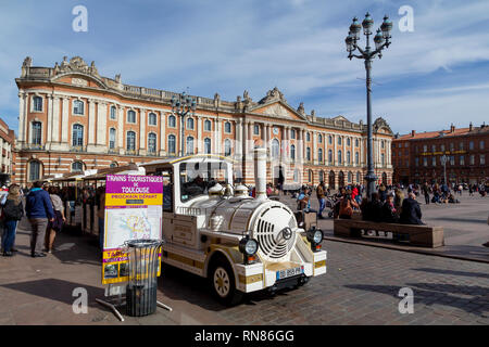 Touristic train for a city tour, in front of the city hall Capitolium in the city of Toulouse Stock Photo