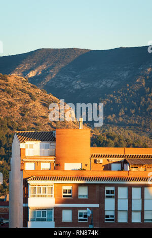Apartament blocks in Spain during sunset with mountains in background Stock Photo