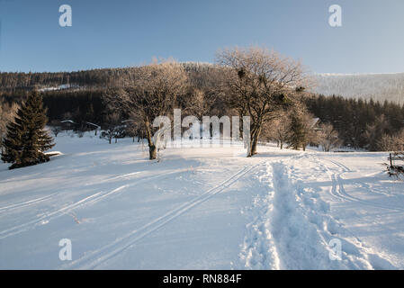 winter morning with snow, hiking trail, few chalets and clear sky on Butoranka bellow Lysa hora hill in Moravskoslezske Beskydy mountains in Czech rep Stock Photo