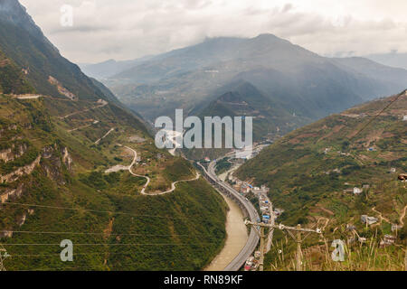 highway passes in a gorge in the mountains along the river, Heng River, Yunnan Province, China Stock Photo