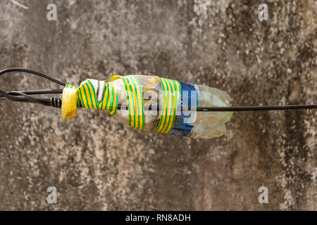 Empty pet bottle used as a junction box, picture from  Phu Quoc Island. Stock Photo