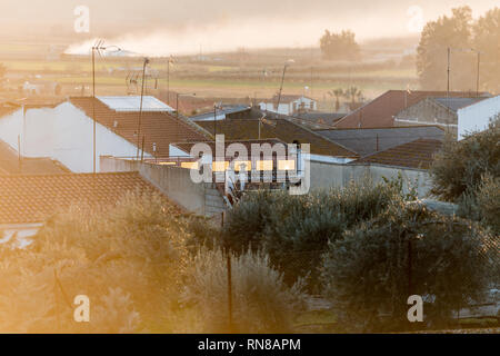 The light of the sunset reflected in the windows and on the roofs of Medellin Stock Photo