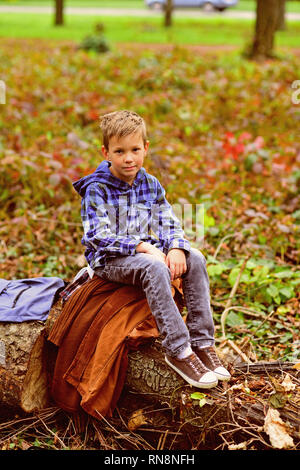 Camping is very special to me. Small boy enjoy camping trip. Small traveler in camping area. Little boy relax on tree in woods. Im really an outdoorsy Stock Photo