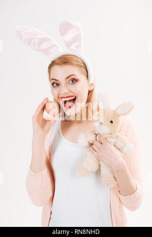 Spring holiday. Girl with hare toy. Happy easter. Woman in rabbit bunny ears. Egg hunt. Easter eggs as traditional food. happy woman in bunny ears Stock Photo
