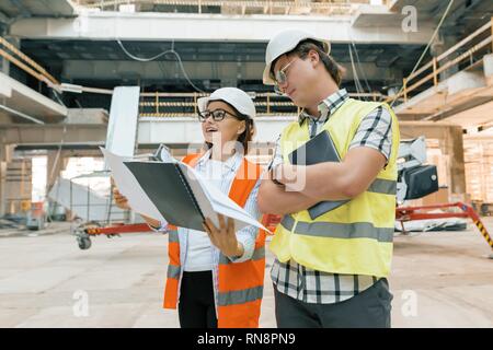 Female construction inspector examining construction site. Building, development, teamwork and people concept. Stock Photo