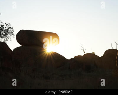 the devil's marbles and sunbeams at sunrise in the nt Stock Photo