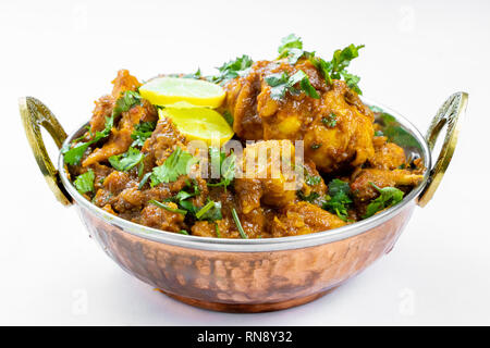 Indian chicken curry close up view, hot delicious indian homemade chicken served in authentic copper bowl. Stock Photo