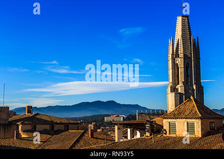 View of Girona Cathedra of Collegiate Church of St. Felix spire and mountains of Puig de la Banya del Boc in the distance