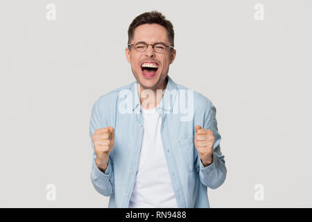 Overjoyed excited funny young man screaming with joy celebrating win Stock Photo