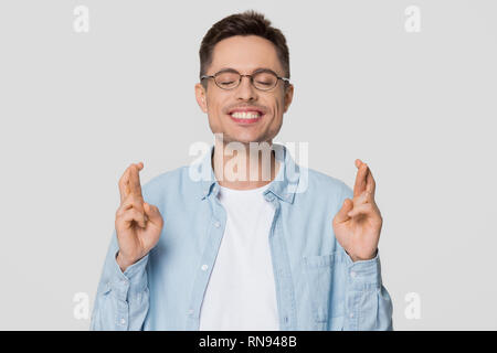 Funny superstitious man hoping wishing for good luck crossing fingers Stock Photo