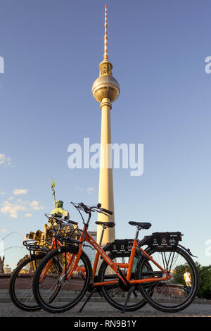 Berlin / Germany - 1 July 2018: Two dockless rental bikes from Donkey Republic bike sharing company in front of the TV Tower Berlin (Berliner Fernseht Stock Photo