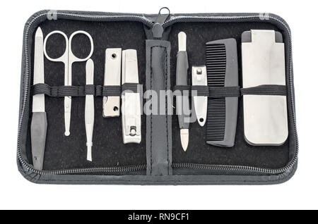 A manicure set with a file, cuticle and nose  scissors, cuticle cleaner, tweezers, toe and nail clippers, comb and shoe horn in a case on an isolated  Stock Photo